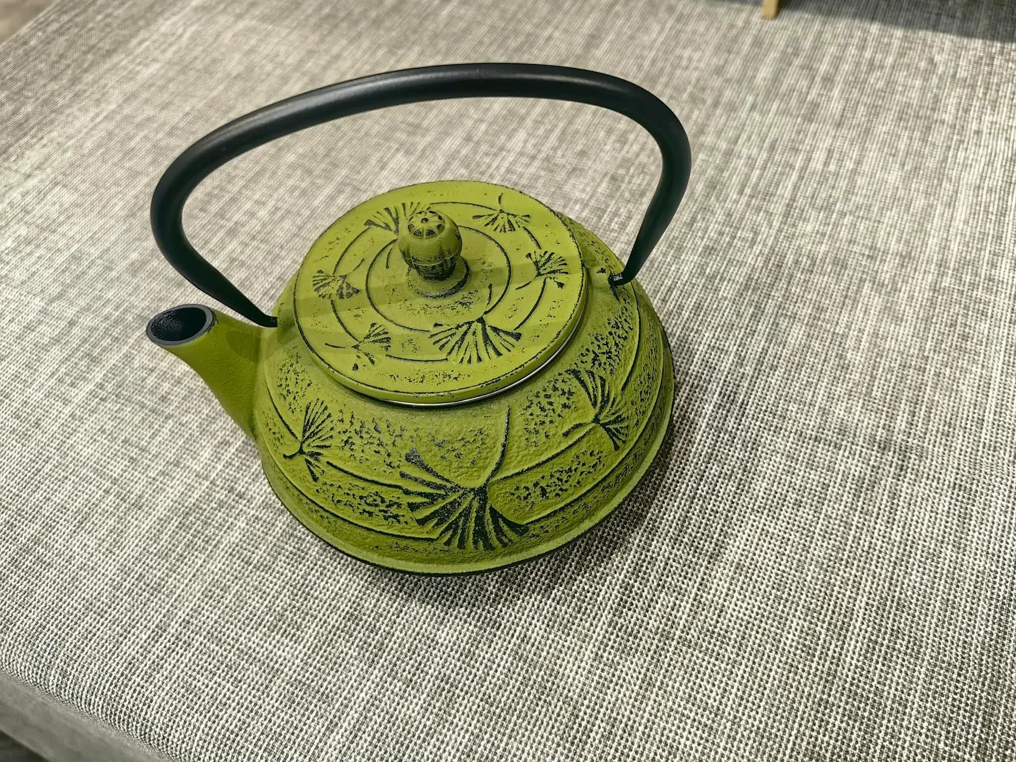 Olive green cast iron teapot with two cups